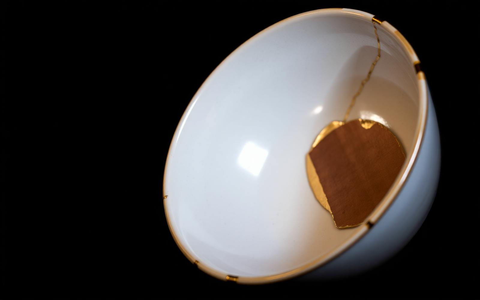 Cuenco japonés reparado con hilos de oro sobre fondo negro